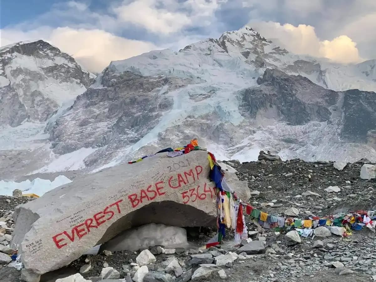 The iconic rock at Everest Base Camp with Lho La and Nuptse in the background is a well known landmark and popular photo spot for trekkers.